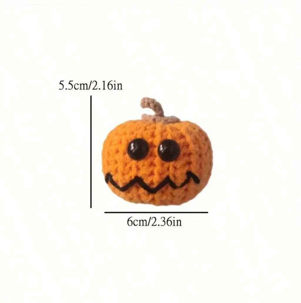 Knitted orange pumpkin with black button eyes and jagged smile, 5.5cm tall