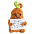 Crocheted pear character holding a punny sign about apples, oranges, and pears