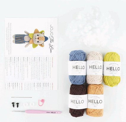 Colorful yarn skeins with pattern and pink crochet hook on white background