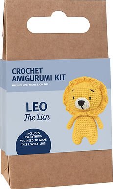 Yellow crocheted lion amigurumi kit in packaging with craft paper background