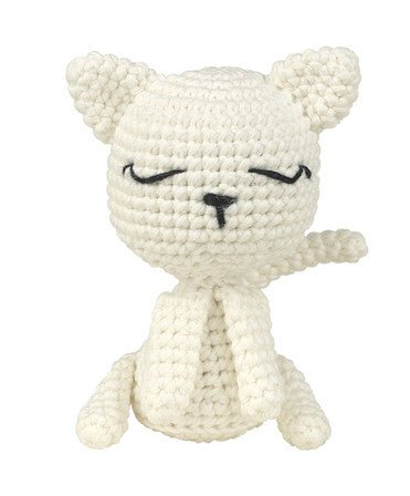 White crocheted cat with closed eyes, sitting cutely with rounded ears and simple features.