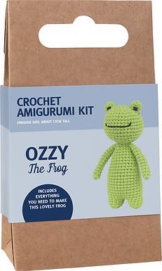 Green crocheted frog amigurumi kit in cardboard packaging with craft design