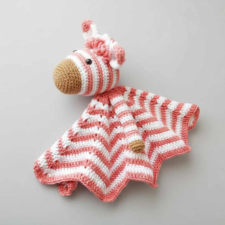 Crocheted pink and white striped lovey security blanket with zebra head and wooden rattle